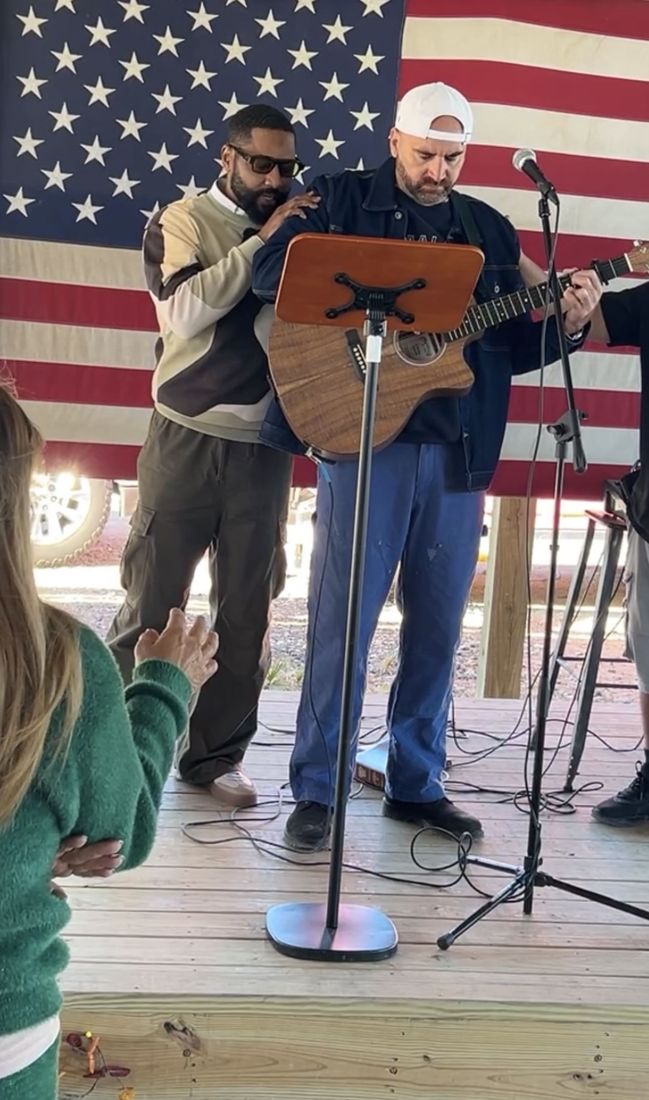 Worship with guitar in front of the American flag